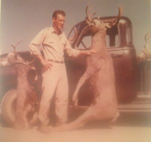 Myron holding up a deer he shot